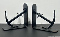 Pair of black wrought iron nautical anchor bookends shown side by side, facing outward.