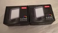 Two boxed Ulanzi VL49RGB Mini LED video lights with RGB branding on front of boxes.