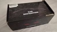 Black box labeled 'Car Navigation' with visible wear and dented corners.