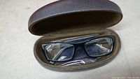 Eyeglasses in case showing rectangular frame and lenses