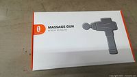 Closed box of Trotronics massage gun with product image and branding visible.