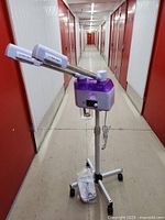 Full view of facial steamer on stand with dual nozzles, in hallway