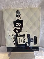 Full view of the Empire Art Direct poster showing a woman sitting on a large Coco Paris Parfum bottle with XO on her top