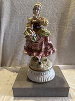 Full front view of entire figurine on base showing pose and colors