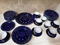 Full assortment of plates, cups and saucers arranged on countertop
