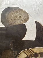 Close-up of the embossed art print showing the textured face and organic shapes around it.