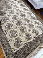Full view of the decorative carpet showing intricate octagonal and geometric pattern, fringe and border detail.