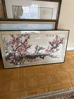 Full view of framed watercolor painting of cherry blossoms leaning against wall