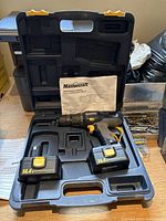 Photo of Mastercraft 14.4V cordless drill kit inside black plastic carrying case with two batteries, manual, and drill bits.