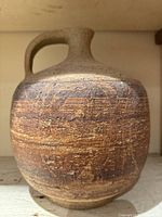 Front view of handmade ceramic jug showing textured mid-century modern abstract design pattern and handle.