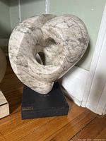 Front view of abstract stone sculpture on black base