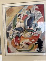 Full view of the framed Kandinsky museum print, showing its abstract shapes and colors with a beige frame and double matting.