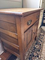 Side angle view of the wood side table showing the drawer and door panel design.