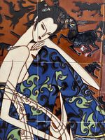 Close-up of ceramic tiles showing the seated woman with patterned blue clothing and surrounding black silhouettes of horses and figures on a brown background