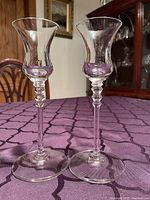 Two clear crystal stem glasses on purple tablecloth