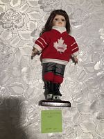 Front view of porcelain Canadian hockey doll on stand