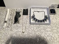 All eight jewellery pieces laid out on lace surface