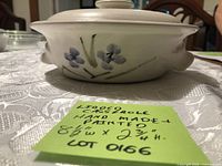 Side view of ceramic casserole with lid displaying floral motif