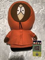 Front view of Kenny plush with tag visible