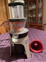 Full assembled juicer with red filter cone beside
