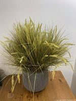 Full view of artificial plant in grey ribbed pot showing natural grass-like foliage with wheat accents
