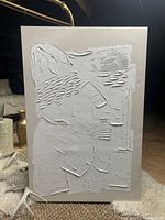 Front view of single wall art panel showing textured spackle applied in abstract shapes and lines on rectangular base board.