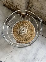 Top-down angled view highlighting the metal wire construction and wooden base of the laundry basket.