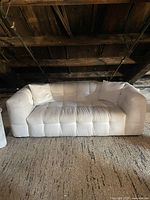 Front view of white bubble couch showing tufted seat and arm cushions.