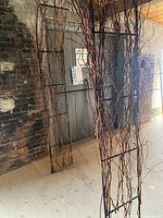 Front side view of the arch showing the wrought iron frame decorated with twisted wood branches.