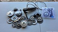 Angle grinder with multiple grinding and cutting discs laid out on a table.