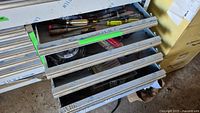 Four drawers from a tool storage cabinet with various tools inside