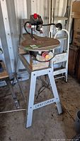 Craftsman Professional 20-inch scroll saw with variable speed control mounted on a Craftsman metal stand in a workshop setting, showing left front angle.