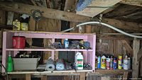 Gardening sprays and supplies on pink wooden shelves, bottles, cans, and gardening chemicals in various containers.