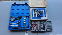 Overall photo of all items including the compression gauge kit, tool kit, and box of positioning squares.