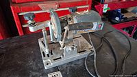 Electric circular saw blade sharpener from front angle showing grinding wheel, motor, and adjustment knobs