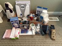 Collection of assorted bathroom accessories, cosmetics, hair dryer attachments, jars with cotton balls, and boxed items