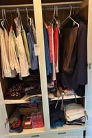 Overview of closet with hanging and folded women's clothing and some accessories like belts and scarves.