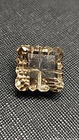 Front view of the square hand carved smokey quartz stone featuring faceted and complex cuts with transparency showing the smoky brown color