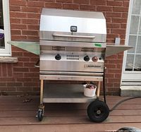 Front view of barbecue grill with closed lid and side shelves extended