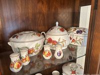 Full view of the Royal Worcester Evesham covered serving dishes and salt and pepper shakers, showing fruit decoration and lids.