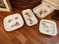 Four different Royal Worcester Evesham serving dishes displayed on wood floor showing fruit and floral designs with gold trim.