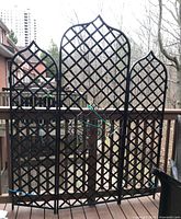 Front view of three-panel cast iron privacy screen on deck railing.