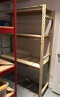 Side view of beige metal framed shelving unit with wooden boards on three levels, showing depth and height.