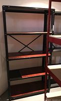 Full view of the five-level metal utility shelf showing black metal frame and brown flooring on shelves.