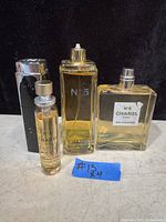 Photo of four Chanel No. 5 perfume bottles, one missing spray nib.