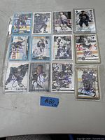 Overview of all 13 signed hockey cards in plastic sleeves, laid out in three rows on a table.