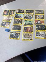 Top down image of yellow bordered vintage Batman trading cards laid out on a table, showing multiple character portraits and scenes from Batman series.