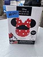Front of boxed Disney Minnie Mouse Jewelry Candle showing Minnie ears and bow design and product details.