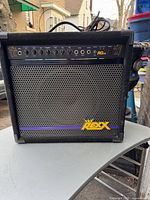 Front view of the black REXX RG45 amplifier showing control panel with knobs, input jacks, and logo on the speaker grille.