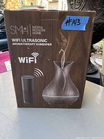 Box showing the WiFi Ultrasonic Aromatherapy Humidifier by Sierra Modern Home. The product is pictured emitting mist on the packaging with a wireless speaker icon indicating WiFi functionality.